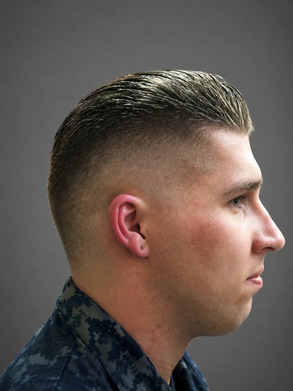 Fair hair cut very short at the sides with a little length combed back on top.